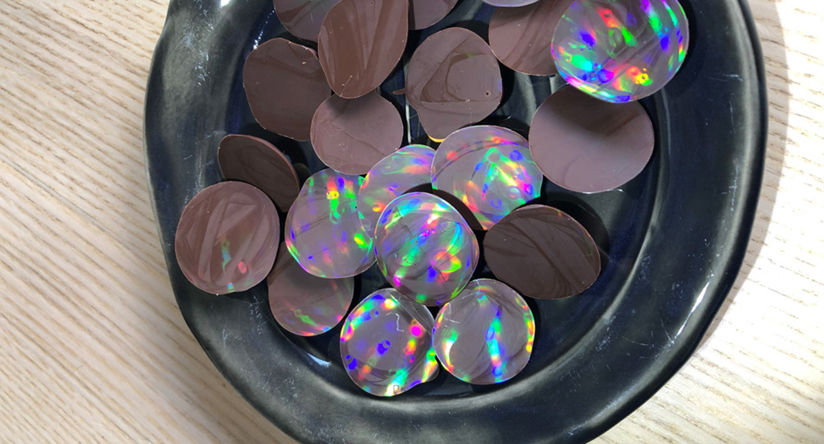 reflets arc-en-ciels holographique sur des petits palets de chocolat