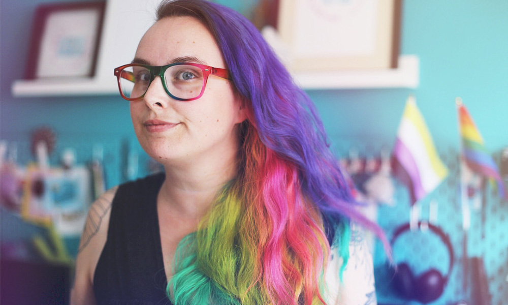 autoportrait : je porte des lunettes avec une monture arc-en-ciel et j'ai les cheveux longs de toutes les couleurs